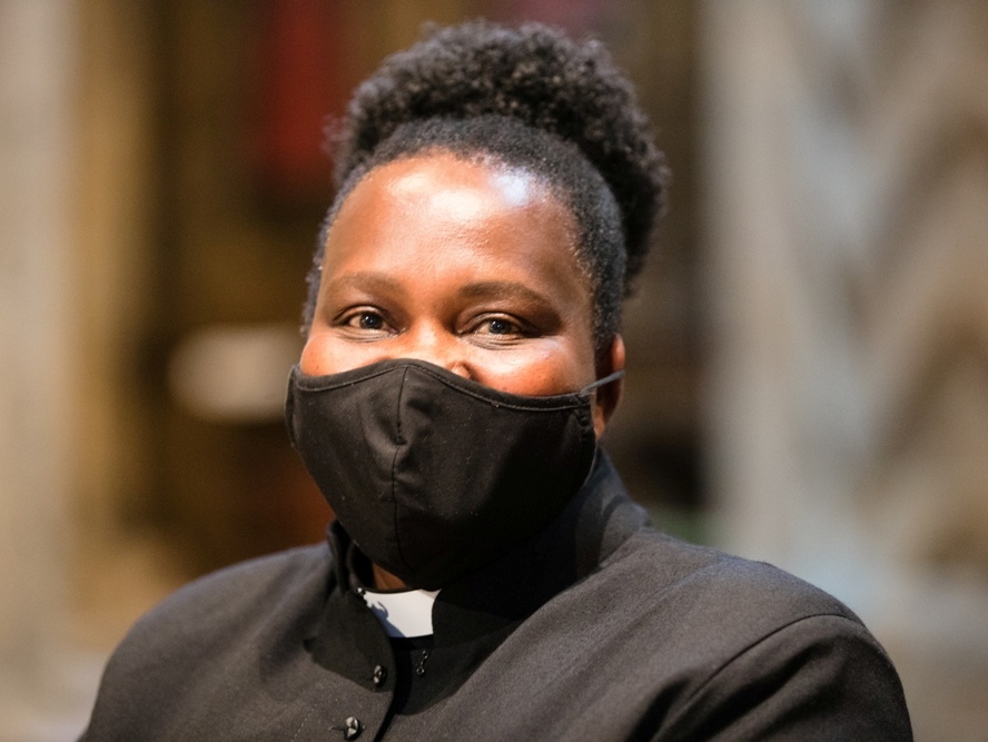Smiling clergy woman masked