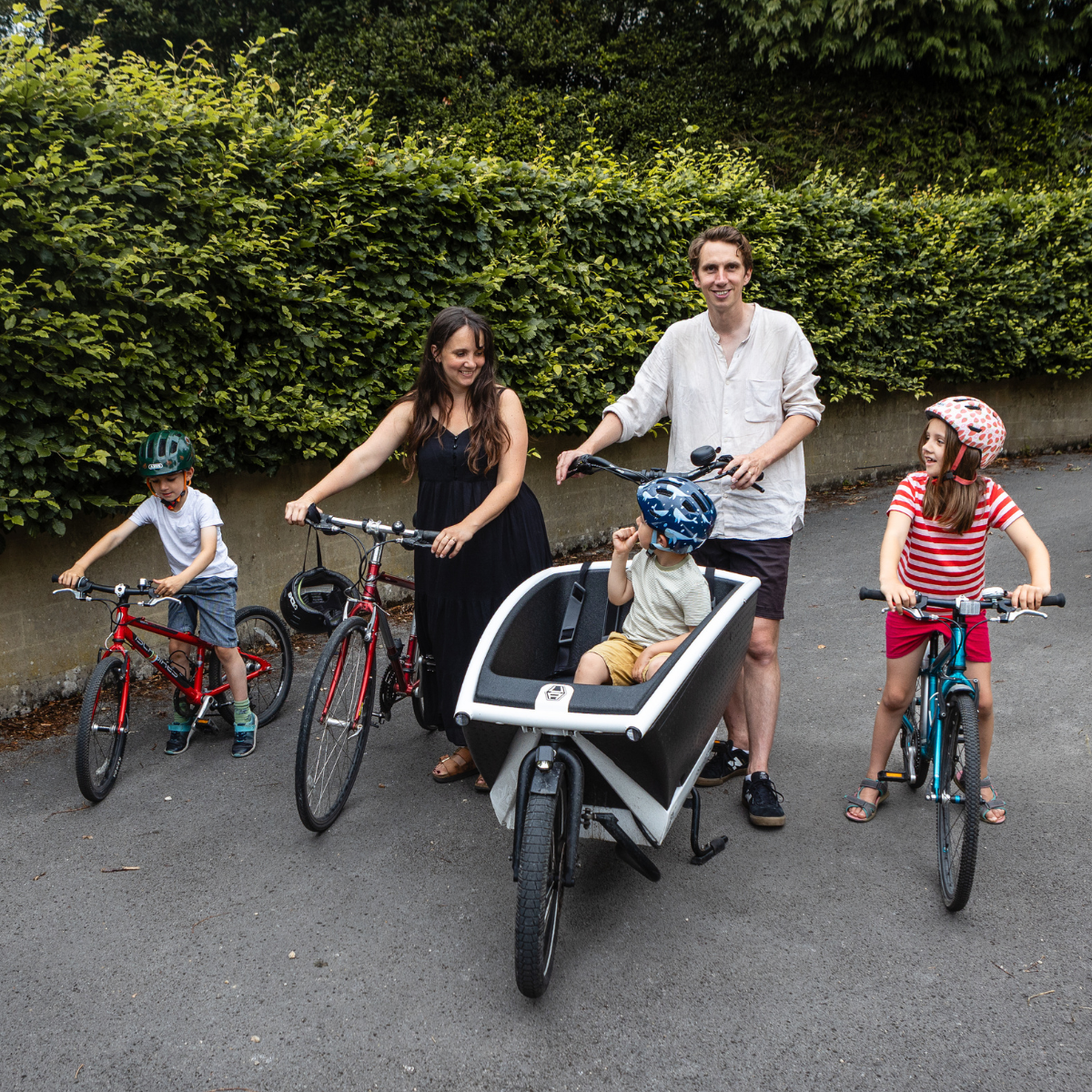 Esther, Matt and their children are riding their bikes along a quiet country lane.