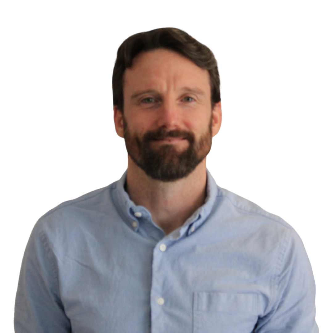 A man, with dark hair and a dark beard, wearing a blue shirt.