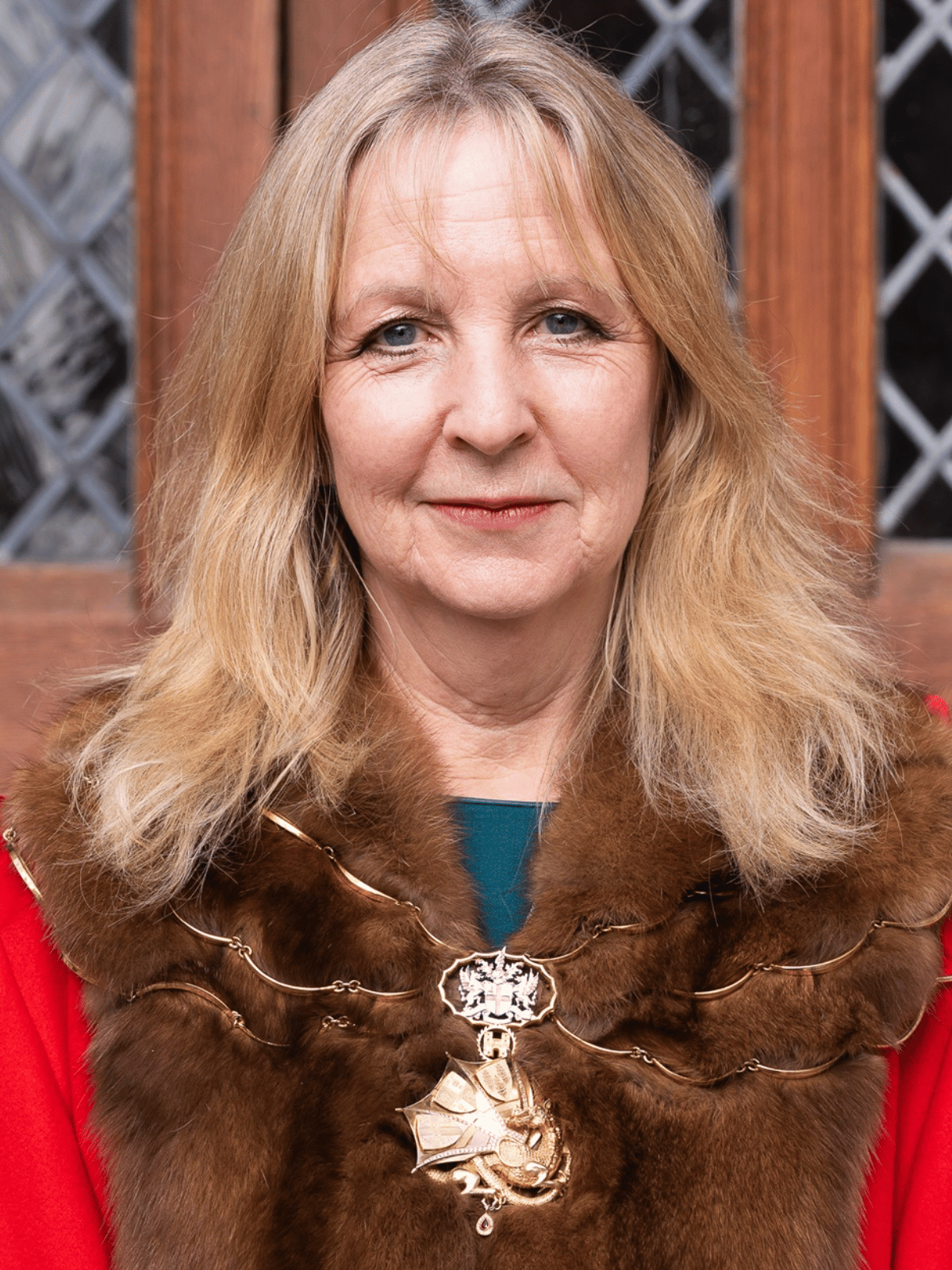Dame Susan Langley DBE, wearing a ceremonial robe of red and brown.