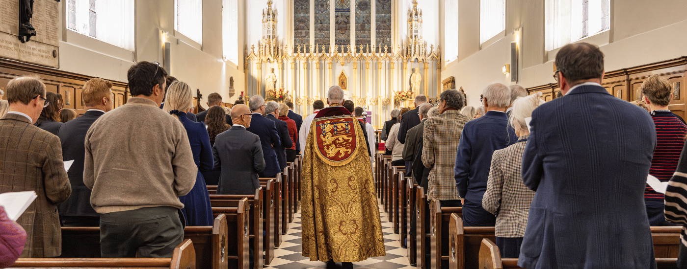 The Revd Canon Thomas Woodhouse, Chaplain of the Royal Victorian Order, walking down the aisle, dressed in a golden robe.