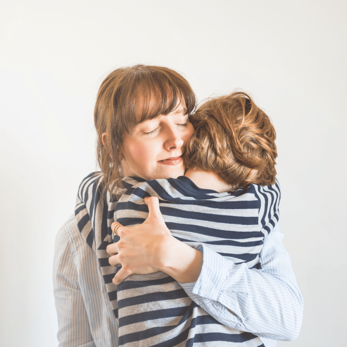 A woman is holding her child in her arms.