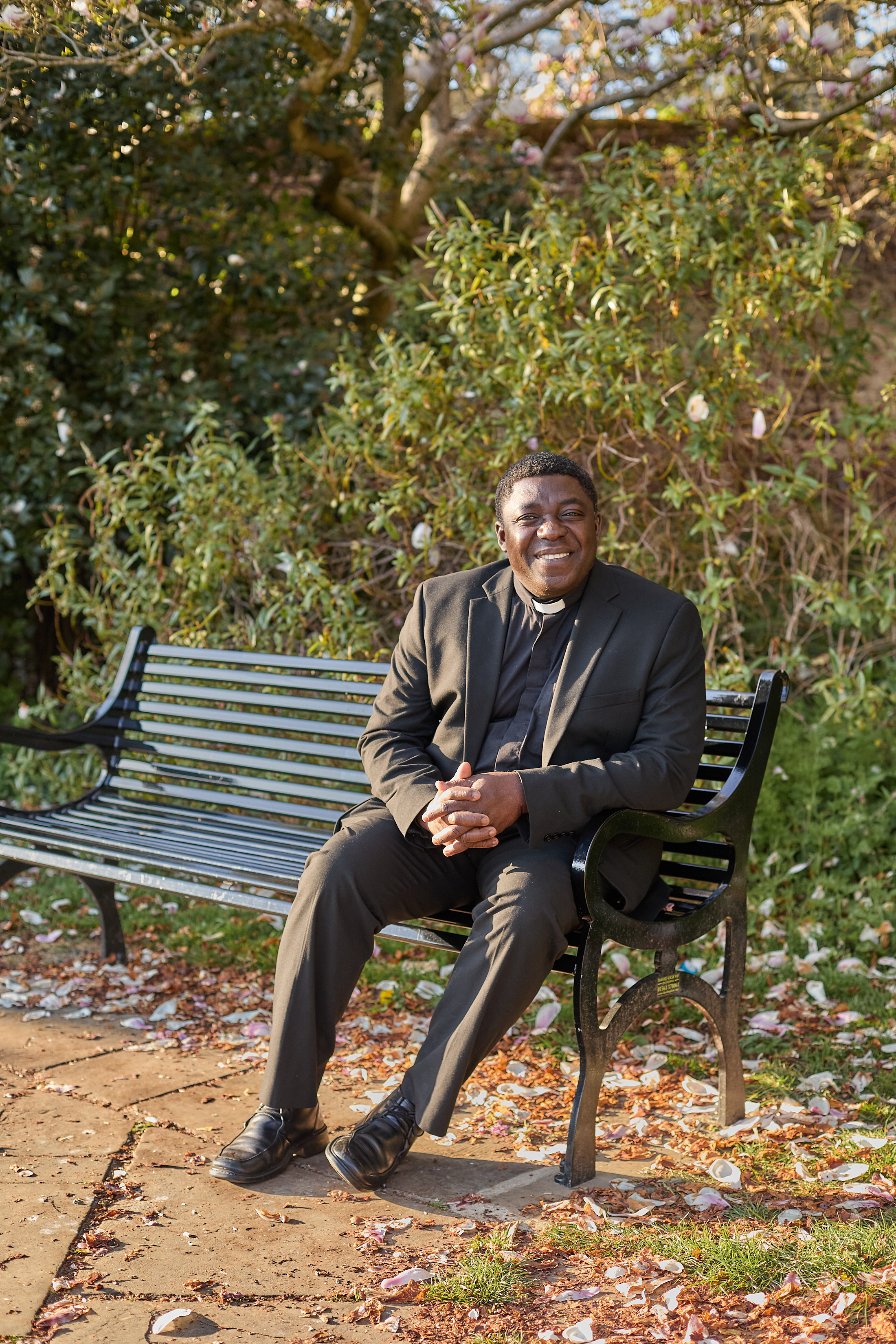 clergy person sat on a bench outside