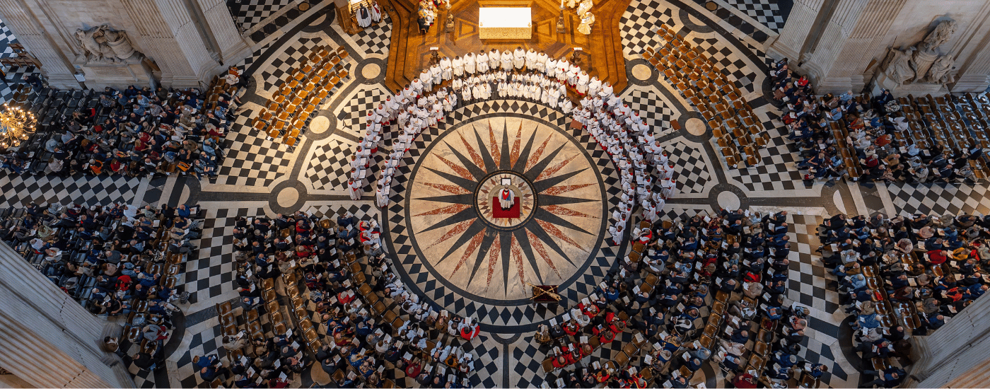 The interior view of St Paul's Cathedral, as seen from the Dome, looking down from the Whisper Gallery. Three choirs, dressed in white and red robes, perform together.