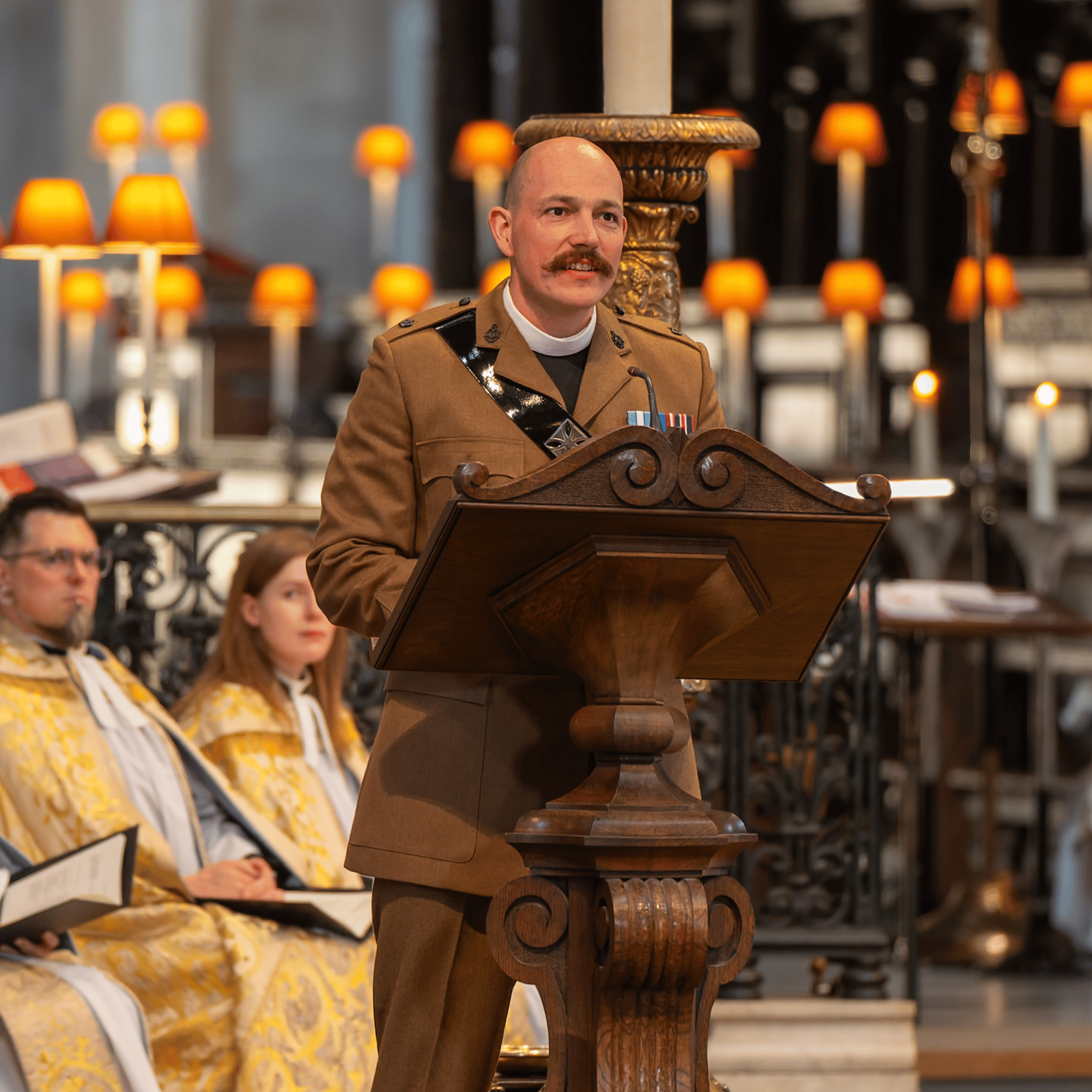 The Revd Nikolas Gower, wearing a military uniform and speaking from behind a wooden lectern.