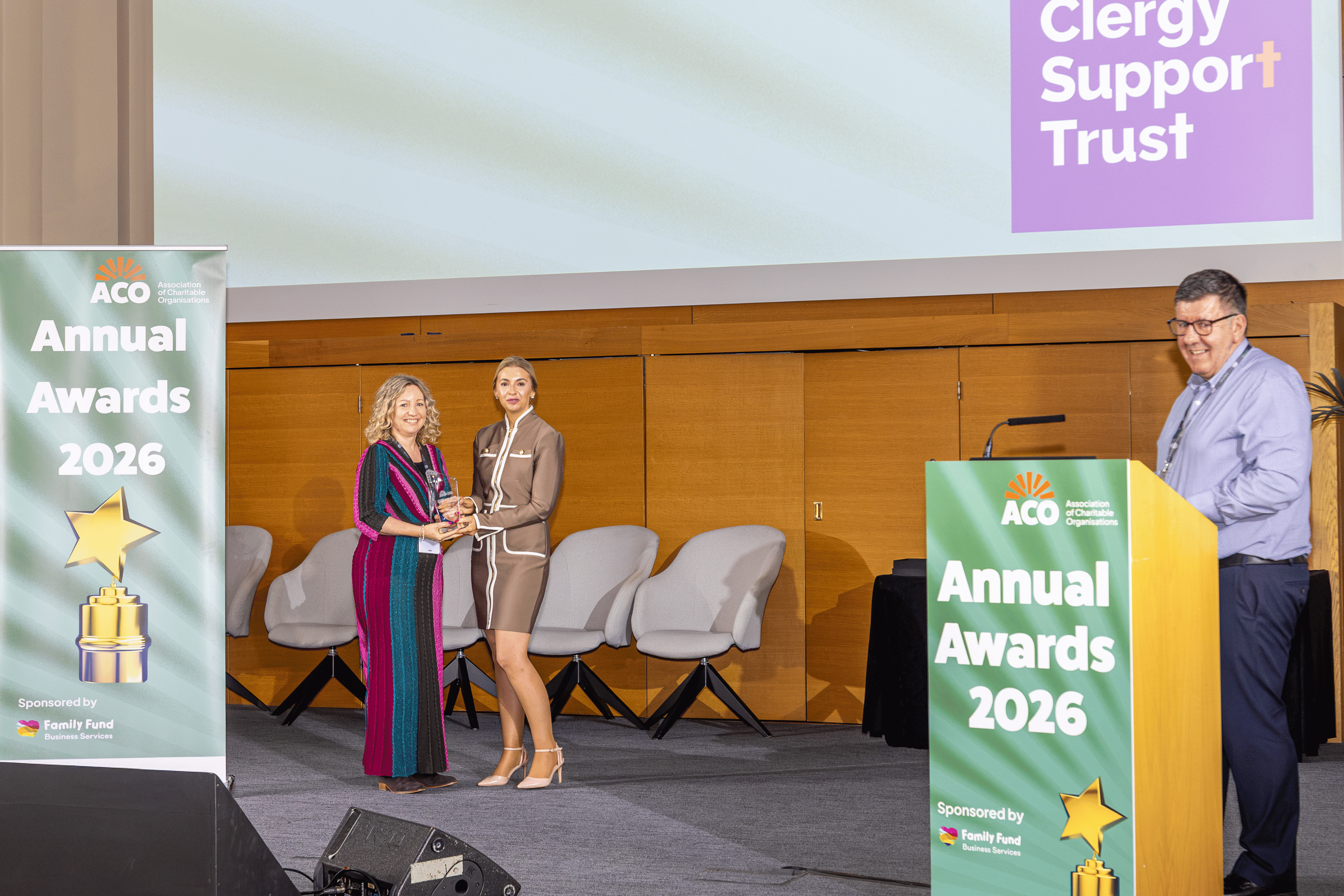 Our Director of Charitable Services, Sarah, accepting the award. Behind her is a projector, displaying the Clergy Support Trust logo.