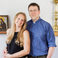 Lucie and Nick, dressed respectively in a black dress, and a blue shirt with glasses.