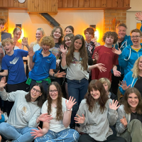 A group of children, waving at the camera.