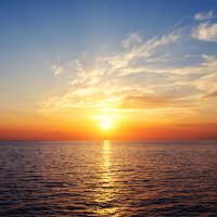 The sun is setting over the ocean.